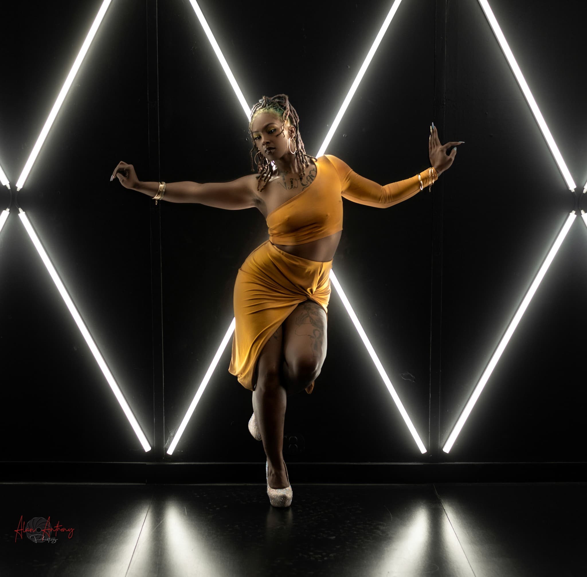 Amber Sarabi Branch modeling in a gold look inside a geometric light installation